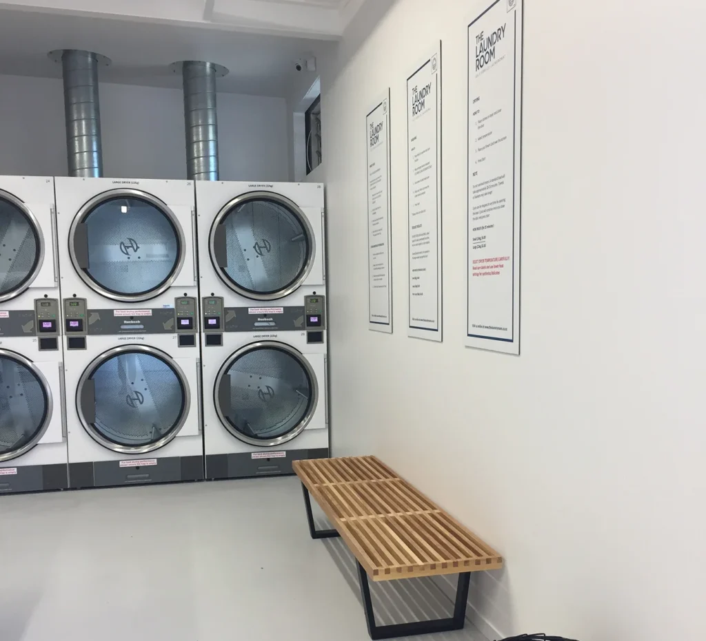 Stacked dryers and a timber bench at our College Street laundromat, Palmerston North
