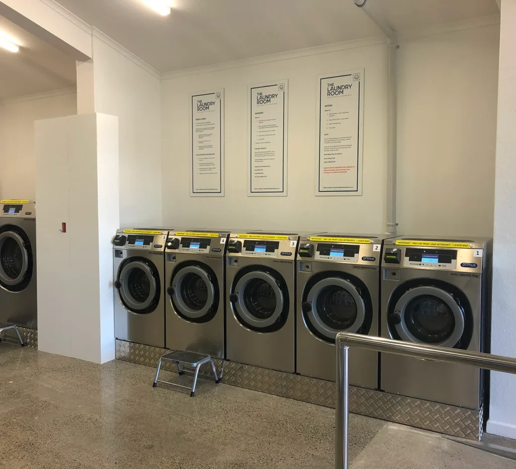 Row of front-loading washers with how-to signs at our Feilding laundromat