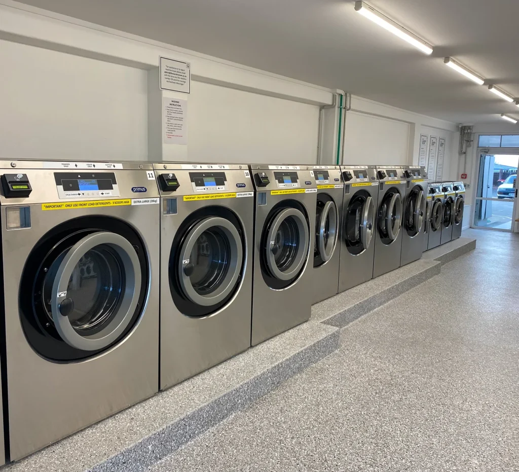 Row of large front-loading washers at our Ōtūmoetai laundromat, Tauranga